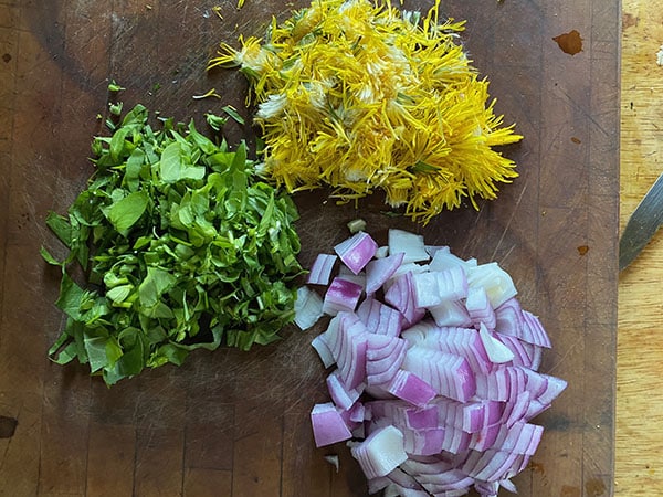 Chopped up dandelion leaves and flowers, chickweed, and red onion